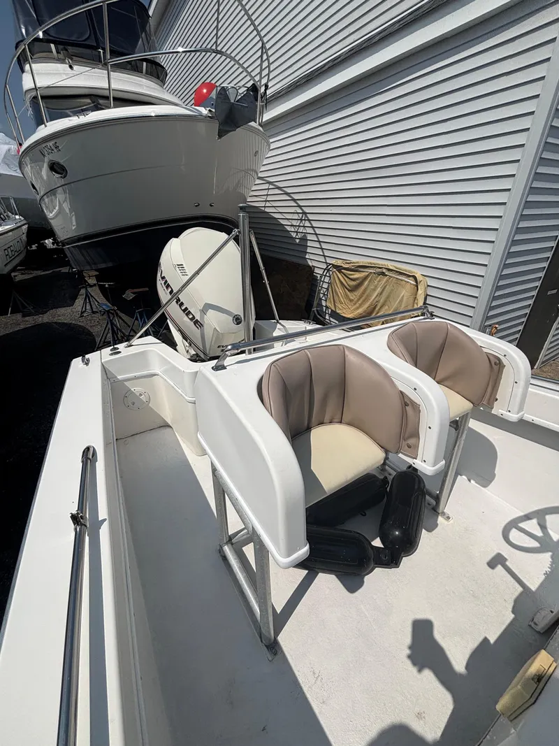 Slide: The Image of 1996 Superboat 24 with dual seats and outboard motor, docked near a larger vessel. - 13