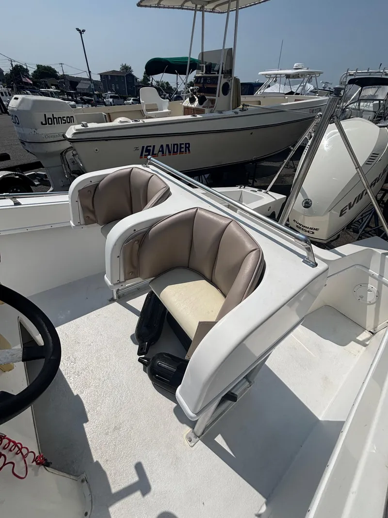 Slide: The Image of 1996 Superboat 24 interior with seating and steering wheel, docked near other boats. - 14