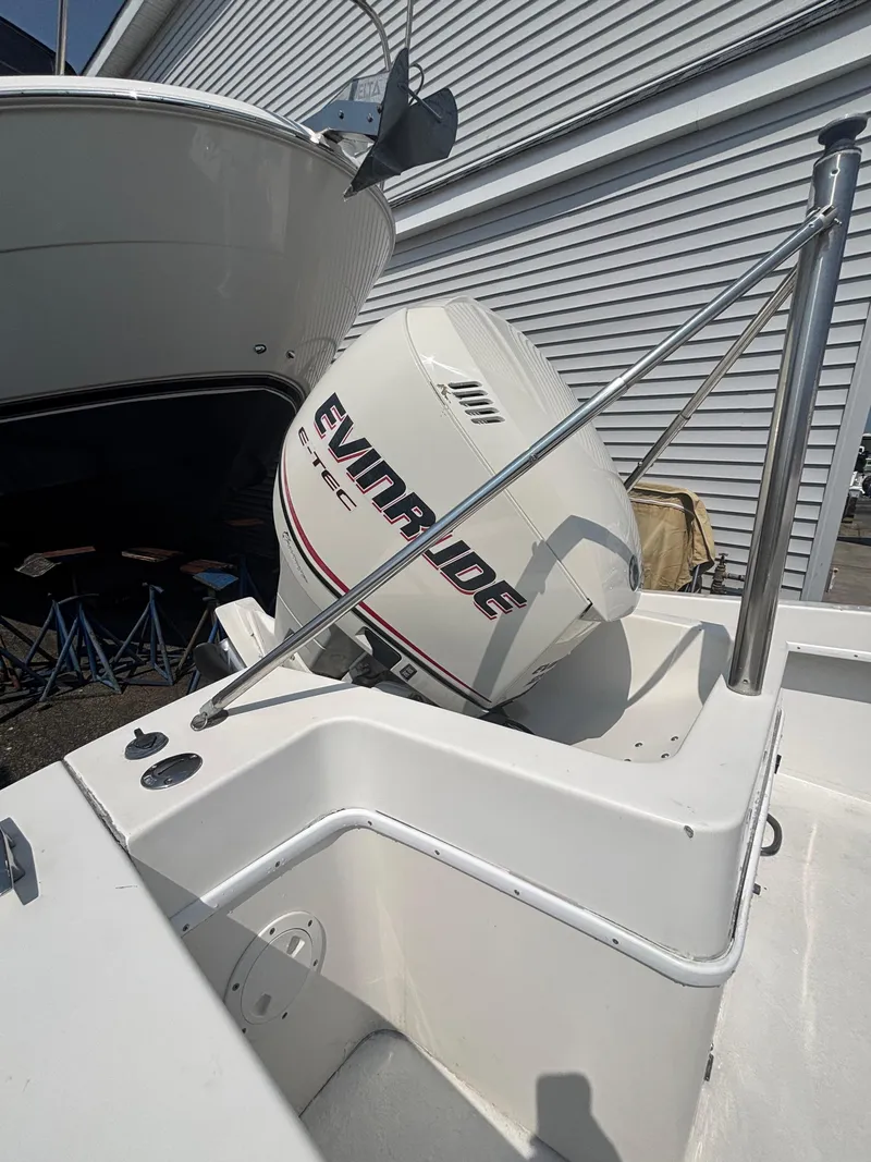 Slide: The Image of 1996 Superboat 24 with Evinrude outboard motor, docked near a building. - 16