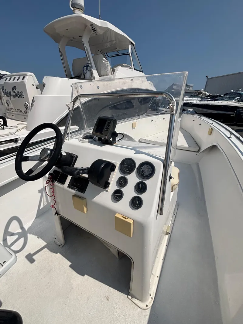 Slide: The Image of 1996 Superboat 24 dashboard with steering wheel and gauges, docked under clear blue sky. - 17