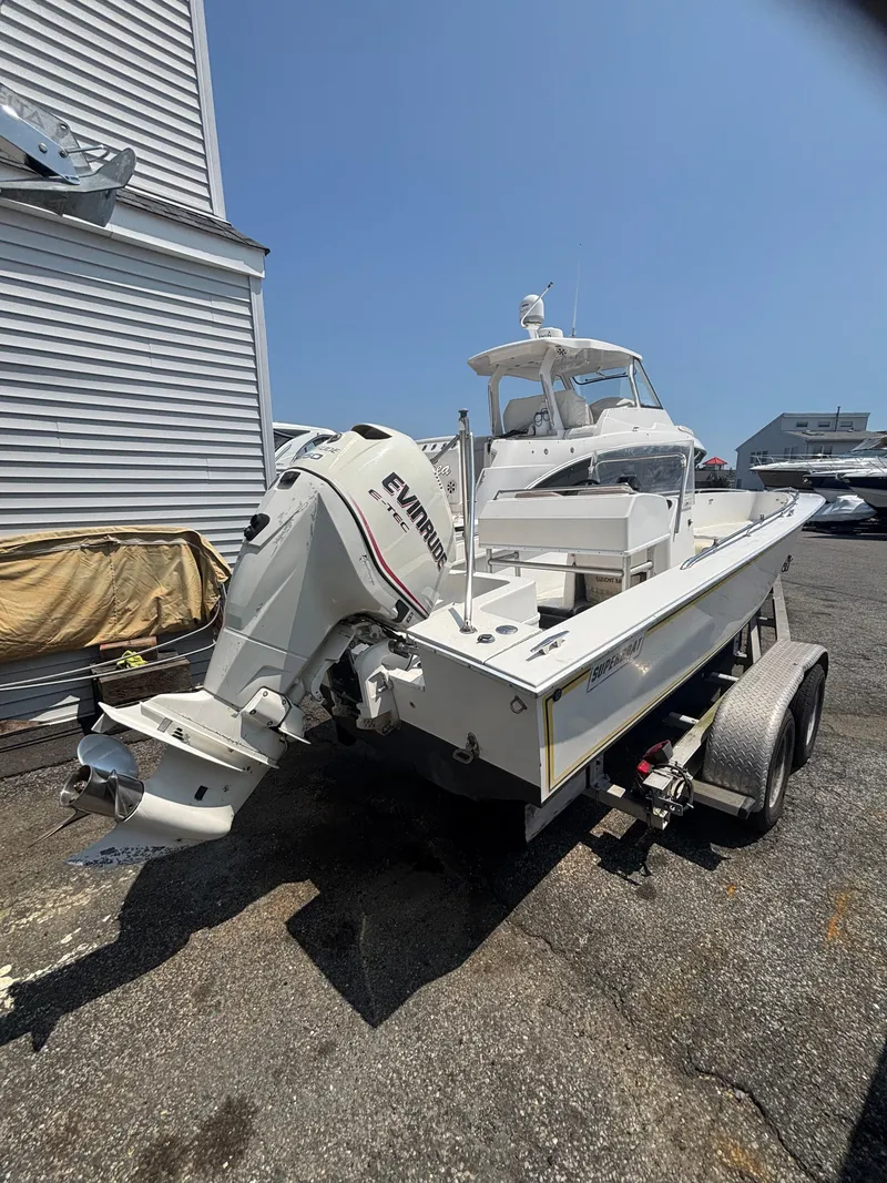 Slide: The Image of 1996 Superboat 24 with Evinrude engine on trailer, parked outdoors. - 20