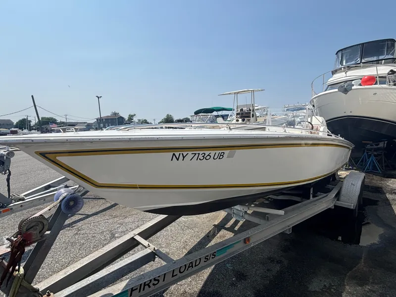 Slide: The Image of 1996 Superboat 24 on trailer, parked in marina under clear blue sky. - 3