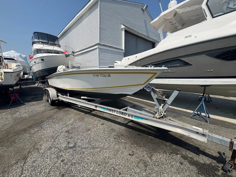 Slide: The Image of 1996 Superboat 24 on trailer, parked among other boats at a marina. - 4