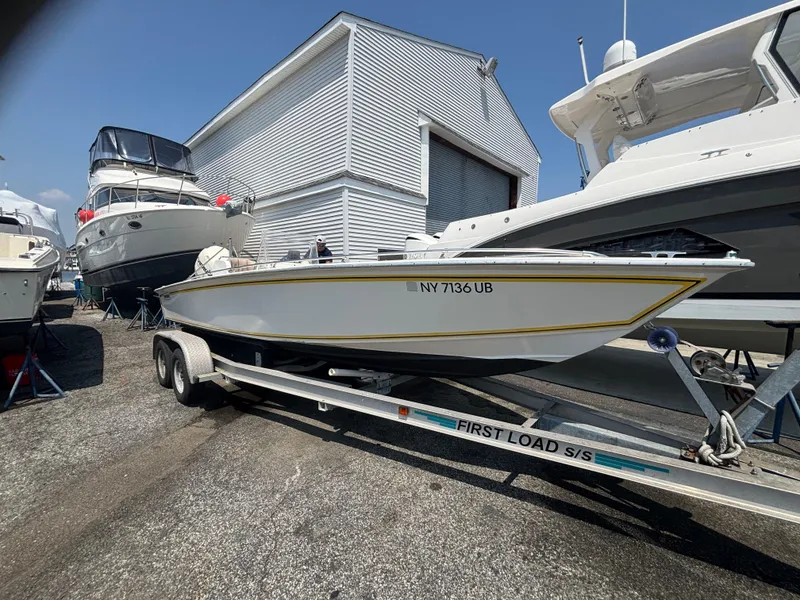 Slide: The Image of 1996 Superboat 24 on trailer, parked near other boats at a marina. - 5
