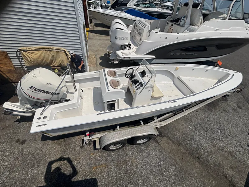 Slide: The Image of 1996 Superboat 24 on trailer with Evinrude outboard motor, parked near other boats. - 9