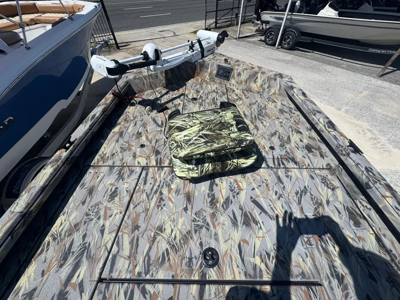 Slide: The Image of 2025 Ranger RB210 boat with camouflage deck and trolling motor, parked outdoors. - 11