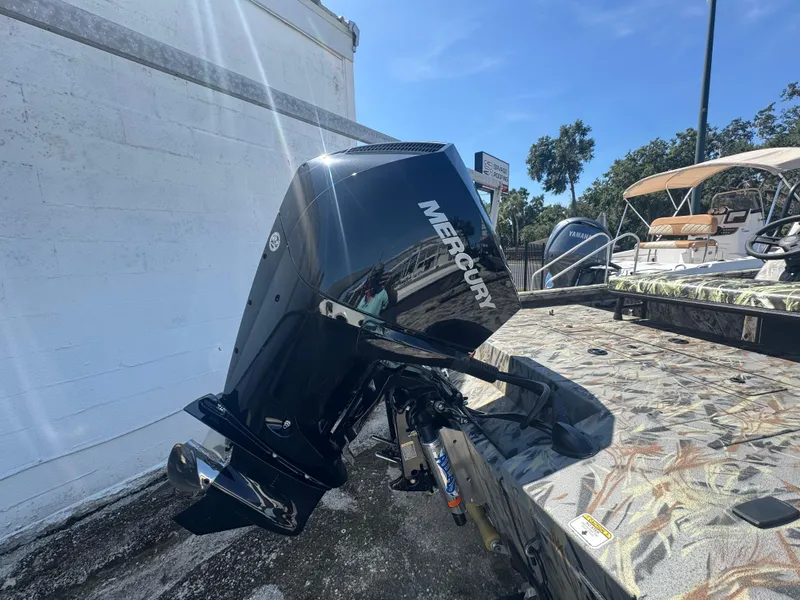 Slide: The Image of 2025 Ranger RB210 boat with Mercury outboard motor, parked outdoors under sunlight. - 3