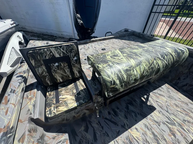 Slide: The Image of 2025 Ranger RB210 boat interior with camouflage seating and flooring, featuring a powerful outboard motor. - 5
