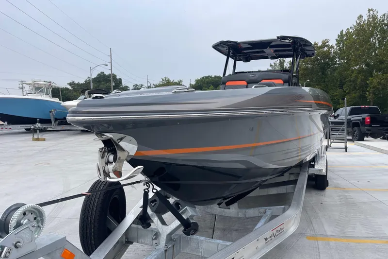 Slide: The Image of 2025 Sunsation 32 CCX boat on trailer, sleek gray design with orange accents. - 10