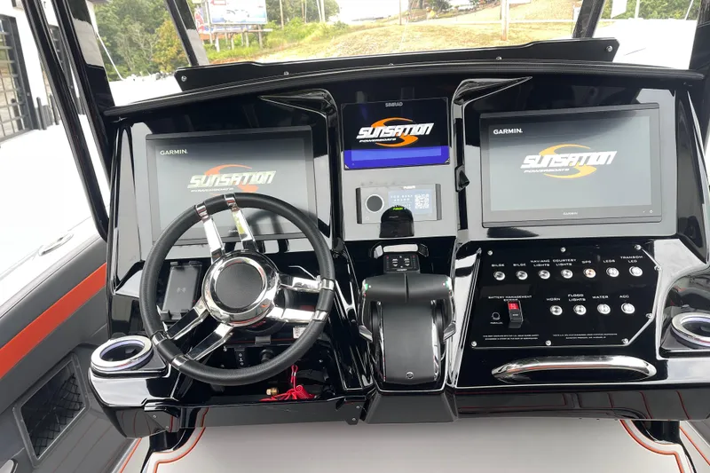 Slide: The Image of 2025 Sunsation 32 CCX boat dashboard with dual Garmin displays and sleek steering wheel. - 15