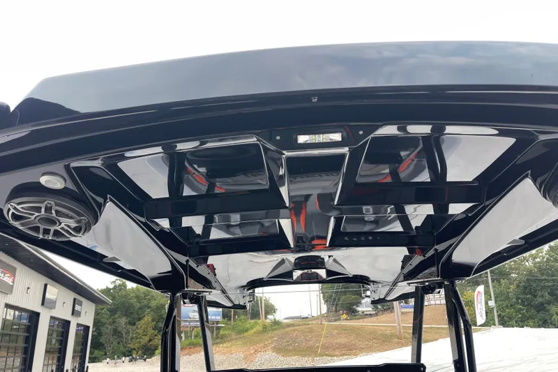 Slide: The Image of 2025 Sunsation 32 CCX boat's sleek black T-top with integrated speakers and lighting. - 16