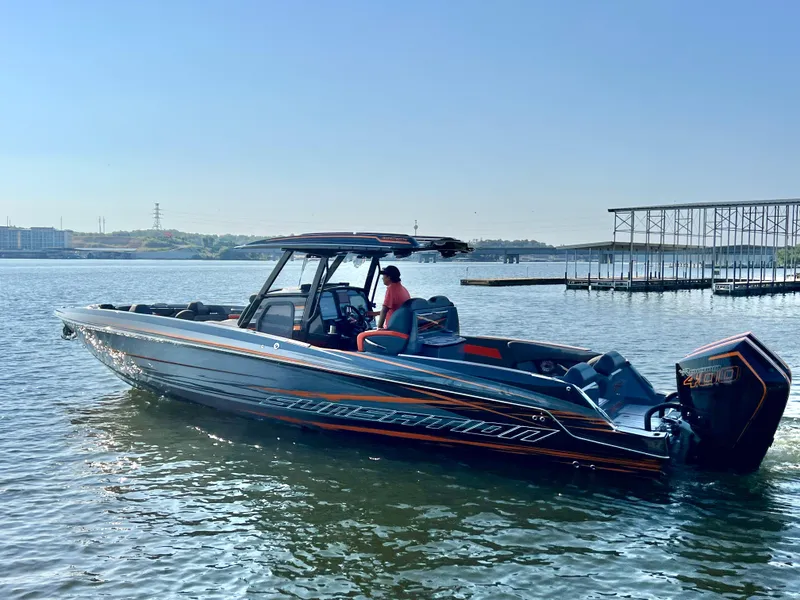 Slide: The Image of 2025 Sunsation 32 CCX boat on a calm lake, featuring sleek design and powerful engines. - 28