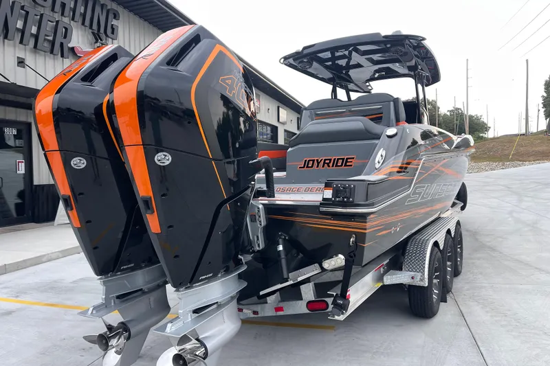 Slide: The Image of 2025 Sunsation 32 CCX boat with dual engines on a trailer, parked outside a building. - 4