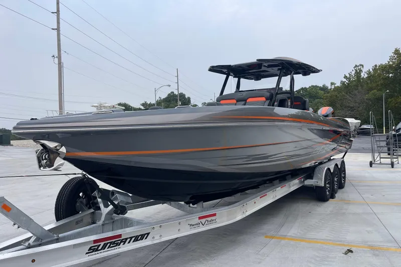 Slide: The Image of 2025 Sunsation 32 CCX boat on trailer, sleek gray design with orange accents. - 9