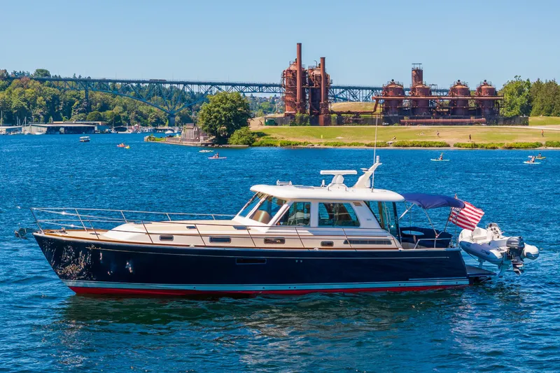 Slide: The Image of 2014 Sabre 48 Salon Express yacht on a scenic blue lake with industrial backdrop. - 0