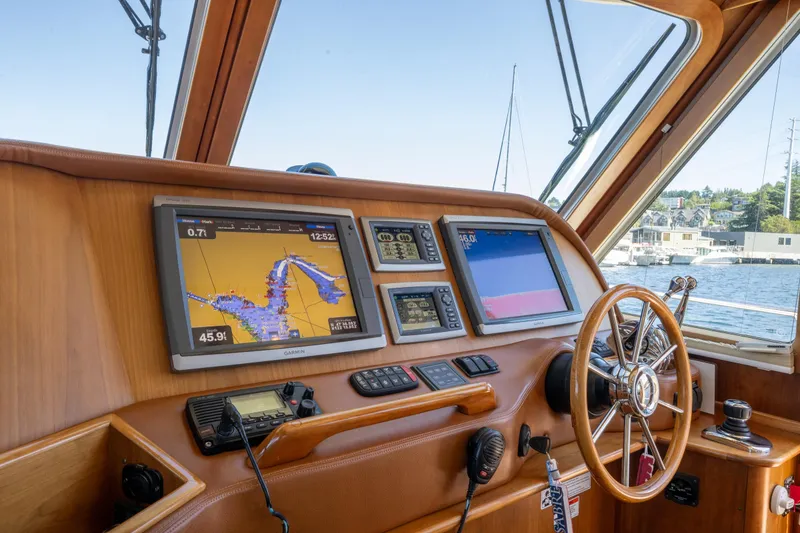 Slide: The Image of 2014 Sabre 48 Salon Express helm with navigation screens and steering wheel. - 15