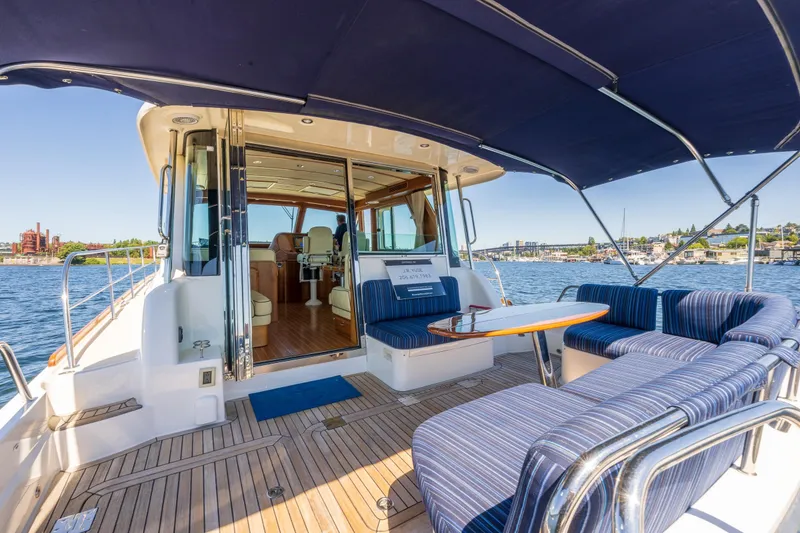Slide: The Image of 2014 Sabre 48 Salon Express yacht with spacious deck and seating, cruising on a sunny day. - 24