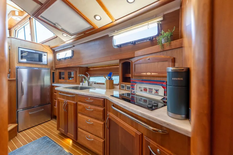 Slide: The Image of Luxurious 2014 Sabre 48 Salon Express yacht kitchen with modern appliances and elegant wood cabinetry. - 26