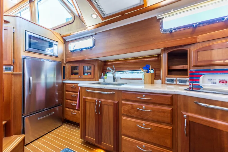 Slide: The Image of Luxurious 2014 Sabre 48 Salon Express yacht galley with wood cabinetry and stainless steel appliances. - 27