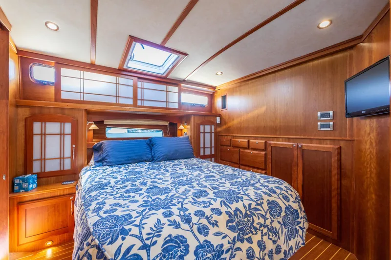 Slide: The Image of Luxurious bedroom interior of 2014 Sabre 48 Salon Express yacht with wood paneling and floral bedding. - 29