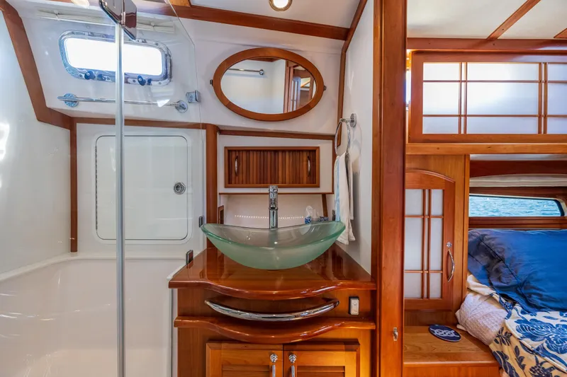 Slide: The Image of Luxurious 2014 Sabre 48 Salon Express bathroom with glass sink and wooden cabinetry. - 34