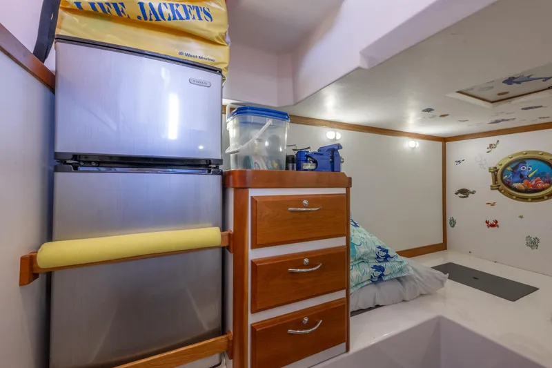 Slide: The Image of 2014 Sabre 48 Salon Express interior with fridge, drawers, and nautical decor. - 40