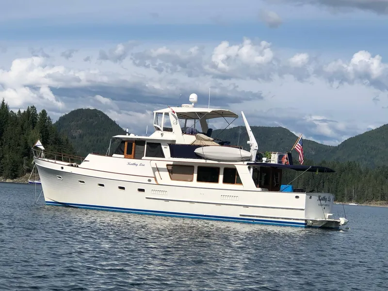 The Image of 1979 Ocean Alexander Mark 1 55 yacht on scenic lake with forested hills. - 0