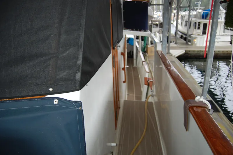 Slide: The Image of 1979 Ocean Alexander Mark 1 55 yacht deck with wooden railings and docked at marina. - 13