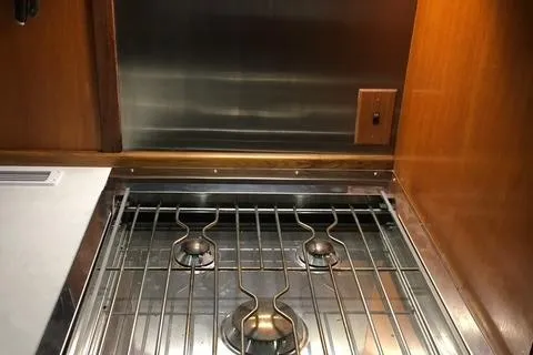 Slide: The Image of 1979 Ocean Alexander Mark 1 55 yacht kitchen stove with wooden cabinetry and stainless steel backsplash. - 25