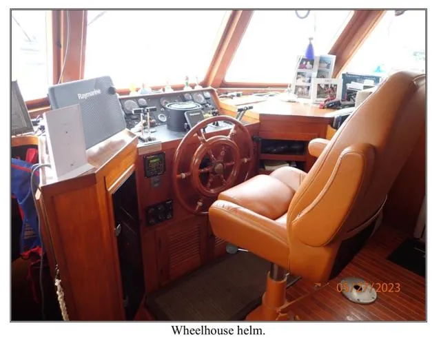 Slide: The Image of Wheelhouse helm of 1979 Ocean Alexander Mark 1 55 yacht, featuring leather seat and wooden steering wheel. - 27