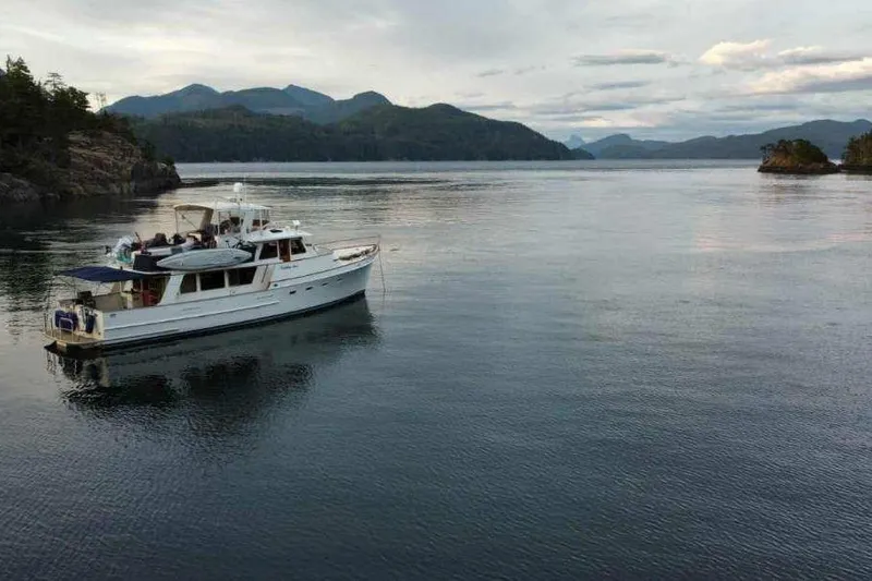 Slide: The Image of 1979 Ocean Alexander Mark 1 55 yacht on serene water with mountainous backdrop. - 3