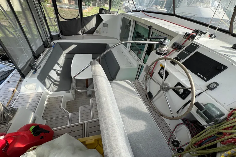 Slide: The Image of 2008 Lagoon 420 yacht cockpit with steering wheel, seating, and navigation equipment. - 10