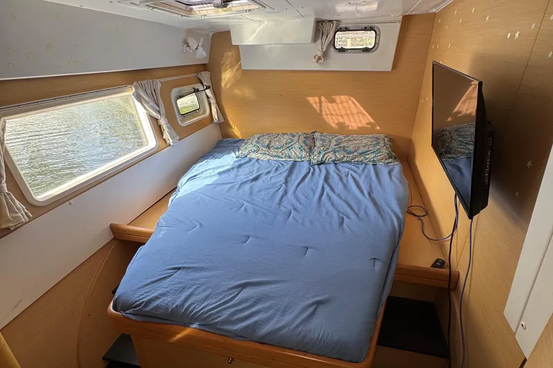 Slide: The Image of Cozy cabin interior of 2008 Lagoon 420 catamaran with bed, windows, and TV. - 13