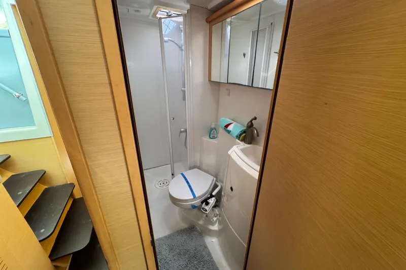 Slide: The Image of Bathroom interior of 2008 Lagoon 420 yacht, featuring shower, toilet, and wooden cabinetry. - 14