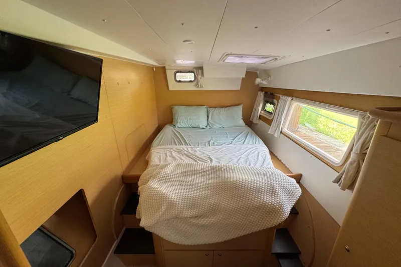 Slide: The Image of Cozy bedroom interior of 2008 Lagoon 420 yacht with bed, windows, and TV. - 19