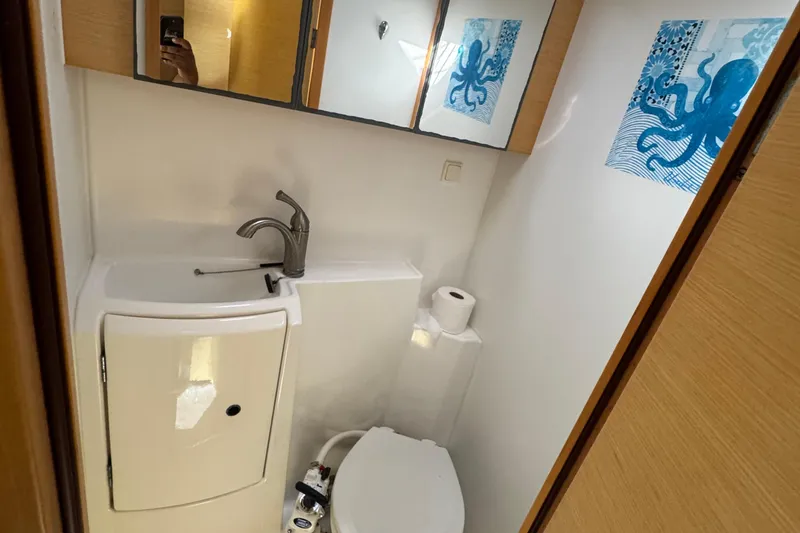 Slide: The Image of Compact bathroom in a 2008 Lagoon 420 yacht, featuring modern fixtures and nautical decor. - 24