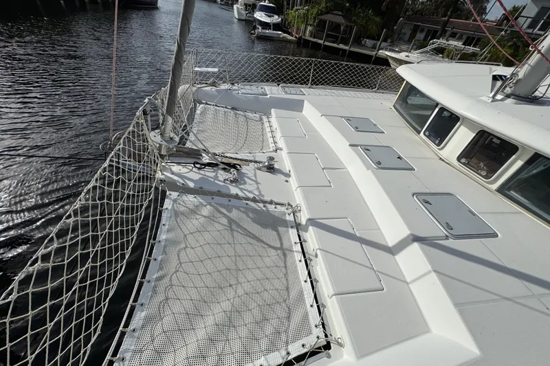 Slide: The Image of 2008 Lagoon 420 catamaran deck with netting, docked in a marina. - 4