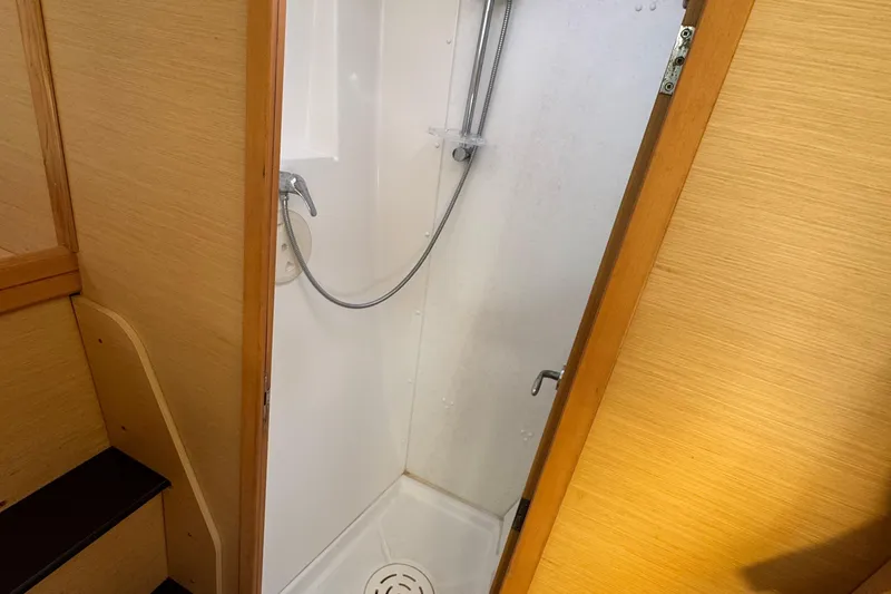 Slide: The Image of Compact shower area inside a 2008 Lagoon 420 yacht, featuring wooden paneling. - 48