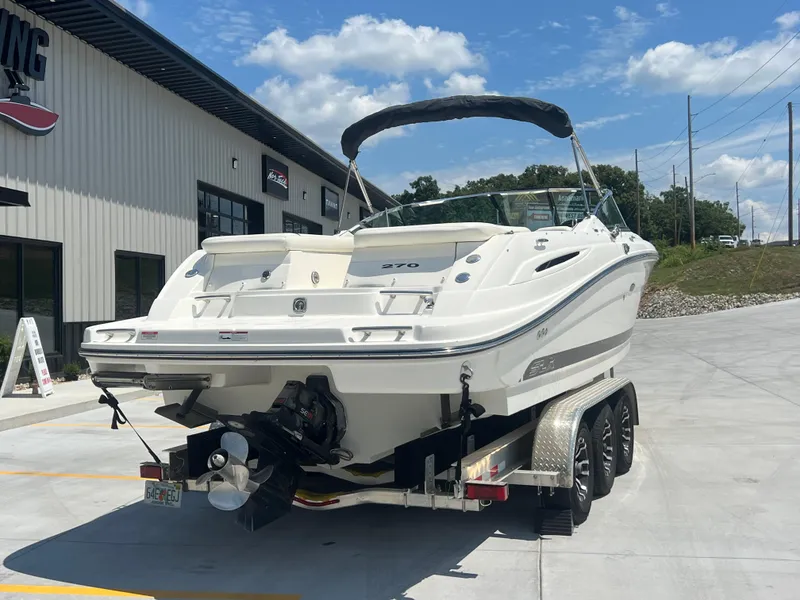 Slide: The Image of 2007 Sea Ray 270 SLX boat on trailer, parked outside a building under a clear blue sky. - 3