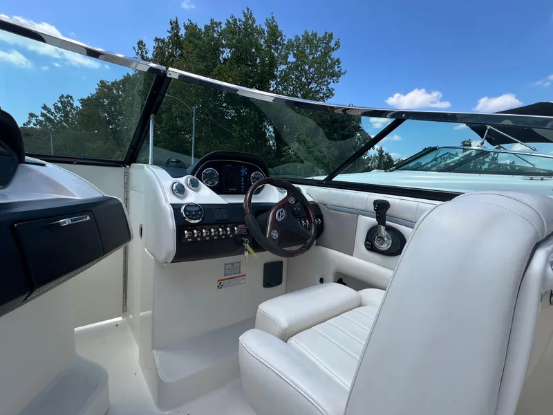 Slide: The Image of 2007 Sea Ray 270 SLX boat interior with steering wheel and dashboard under blue sky. - 9