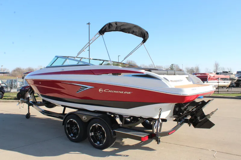 Slide: The Image of 2024 Crownline 240 SS boat on trailer, red and white design, outdoor display. - 10