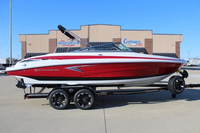Slide: The Image of 2024 Crownline 240 SS boat in red on a trailer, parked outside a dealership. - 12