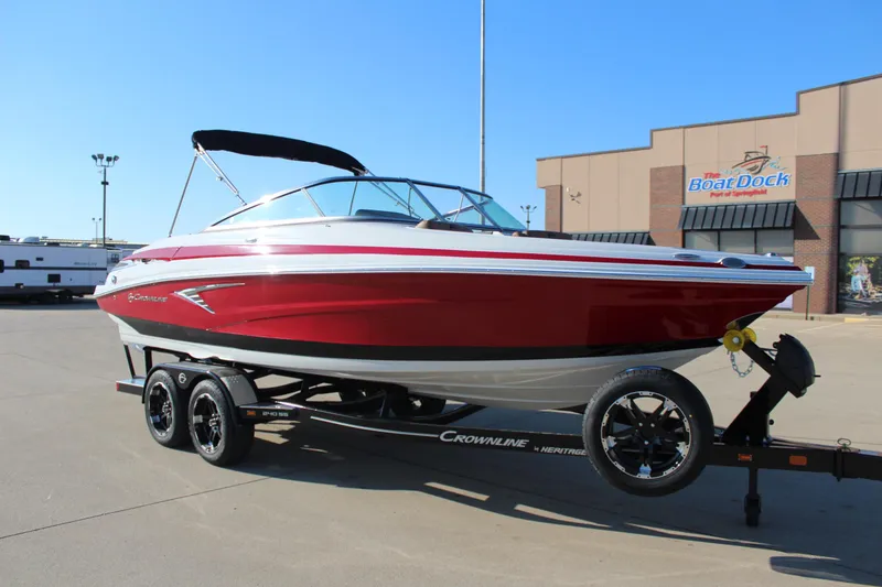 Slide: The Image of 2024 Crownline 240 SS boat on trailer, red and white design, parked at dealership. - 13
