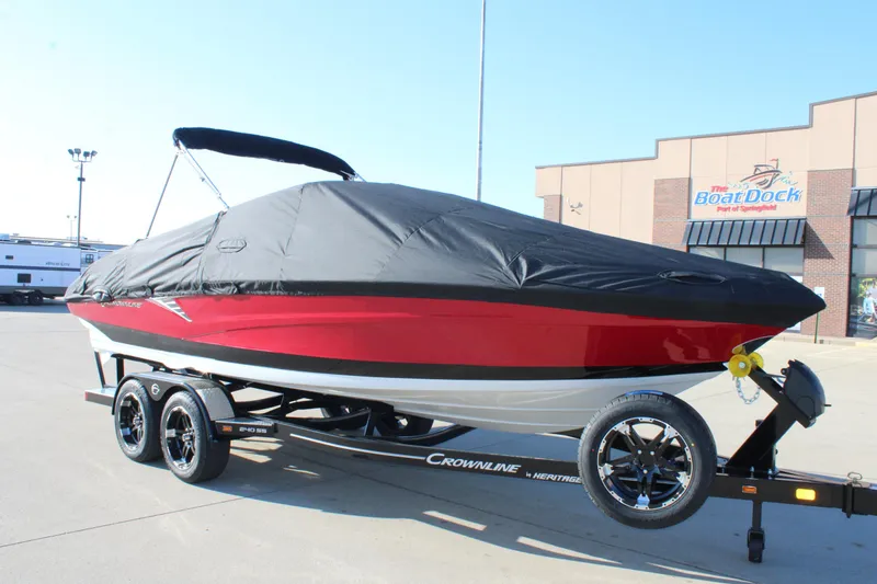 Slide: The Image of 2024 Crownline 240 SS boat with cover on trailer, parked outside dealership. - 14