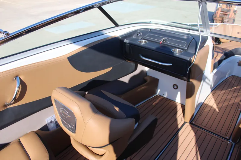 Slide: The Image of 2024 Crownline 240 SS boat interior with tan and black seating, sleek dashboard, and wood-style flooring. - 5