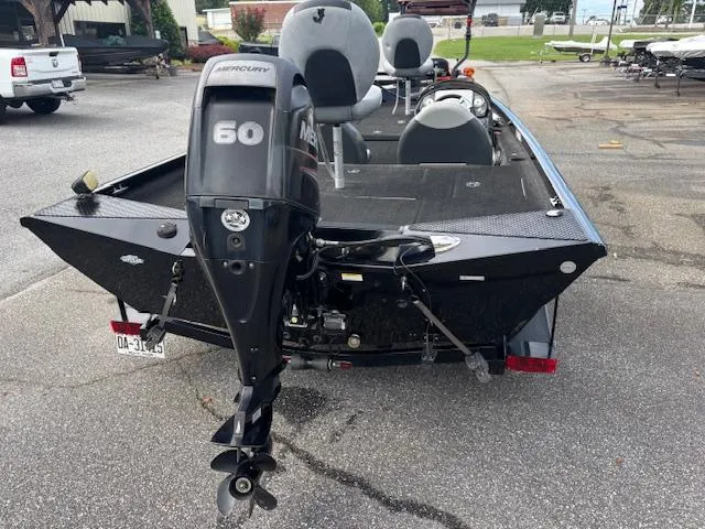 Slide: The Image of 2016 Triton 17 CTX boat with Mercury 60 outboard motor, parked on pavement. - 3