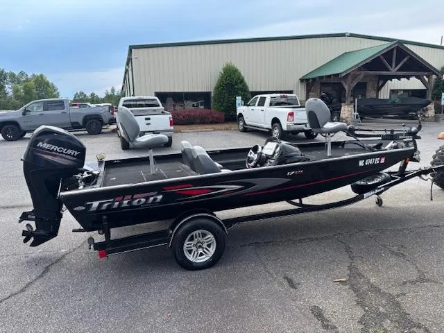 Slide: The Image of 2016 Triton 17 CTX fishing boat with Mercury outboard motor, parked outdoors. - 4