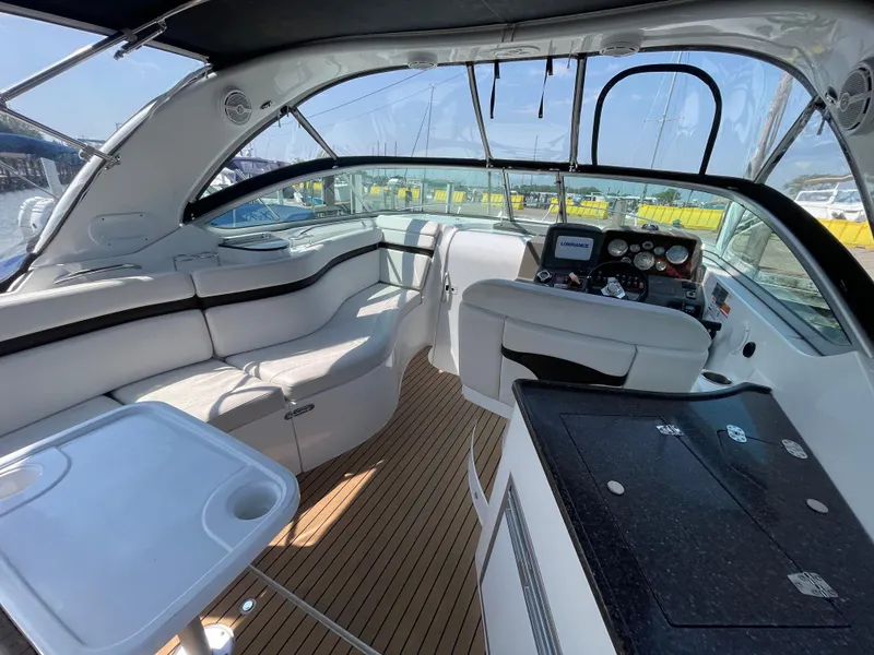 Slide: The Image of 2013 Rinker 310 Express Cruiser interior with seating, helm, and table. - 11