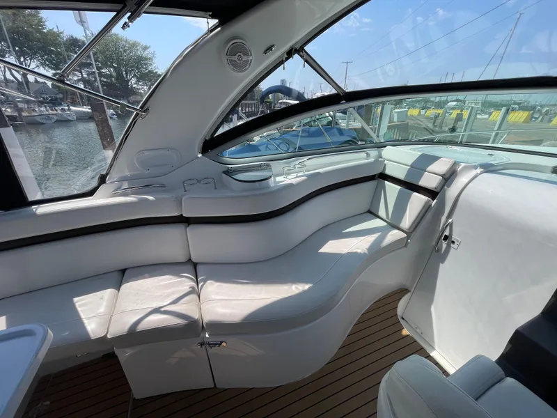 Slide: The Image of 2013 Rinker 310 Express Cruiser interior with white seating and wood flooring. - 12
