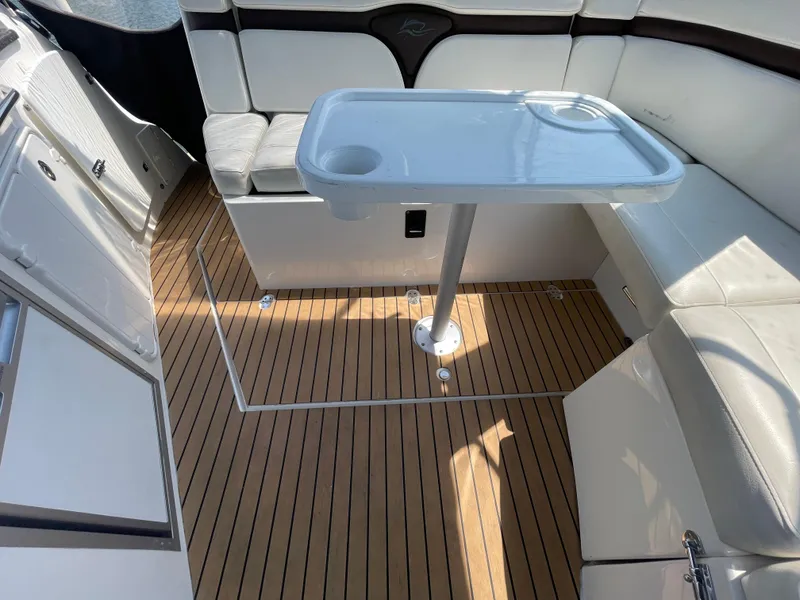 Slide: The Image of 2013 Rinker 310 Express Cruiser interior with white seating and wooden flooring. - 14